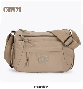 Front view of khaki nylon crossbody bag showing multiple zipper pockets and adjustable strap