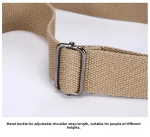 Detail of adjustable gunmetal buckle and beige canvas shoulder strap on bag