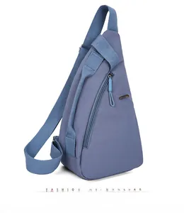 Detail of blue nylon chest bag with waterproof fabric, metal logo and front zipper pocket