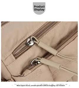 Detail of smooth metal double zippers with durable cord pulls on nylon shoulder bag