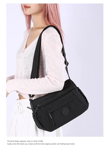 Close-up of lightweight black nylon crossbody bag with multiple functional zippers