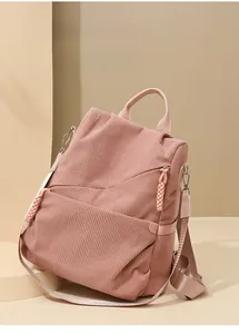 Close-up of pink corduroy texture and sturdy nylon shoulder straps on the backpack