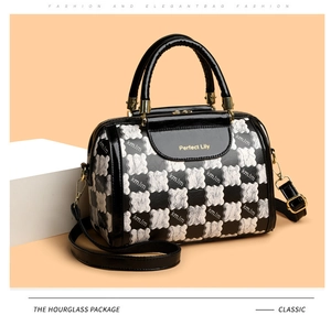 Detail view of stylish Boston bag with KMJM letter print and golden hardware accents