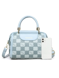 Detail of light blue handbag with letter pattern and gold hardware next to a smartphone