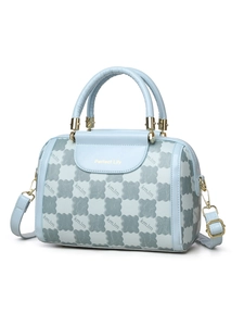 Detail of light blue crossbody bag featuring bear checkered pattern and golden hardware