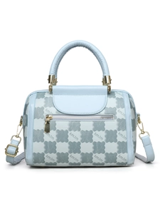 Detailed macro of a light blue Boston bag with gold hardware and kmJm monogram print