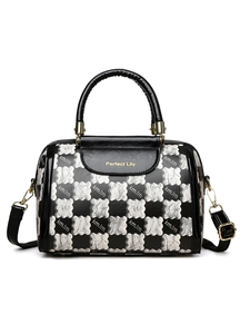 Detail of checkered women's tote bag with metal brand logo and sleek black handle