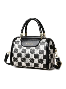 Detail of Boston handbag featuring checkerboard texture, gold hardware and leather handles