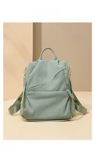 Detail of mint green corduroy backpack showing textured fabric and asymmetric zipper pocket