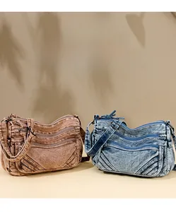 Detail view of retro denim crossbody bags with multiple zippers in blue and brown colors
