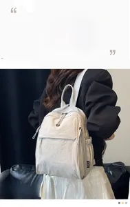 Détail d'un sac à dos beige montrant la texture du tissu et les fermetures éclair