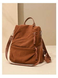 Detail of brown corduroy backpack showing woven zipper pull and soft ribbed texture