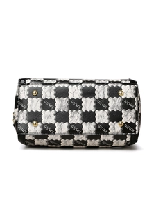 Detail view of the black and white checkered handbag bottom with gold protective studs