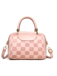 Detailed close-up of pink Boston handbag with golden logo and patterned checkered design