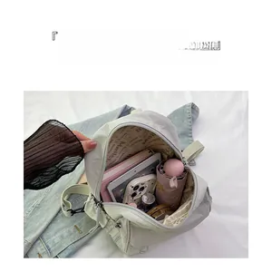 Vue intérieure du sac à dos minimaliste montrant des compartiments spacieux et divers objets