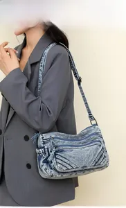 Side view of a vintage blue denim tote bag with functional multi-layer zipper pockets