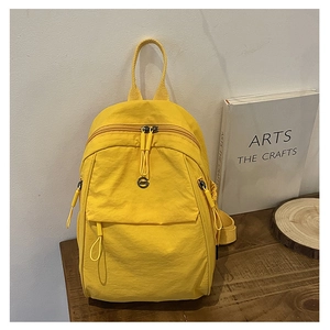 Détails du sac à dos en nylon jaune avec texture gaufrée et logo métallique