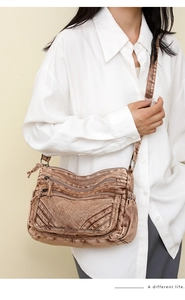 Detail of vintage brown multi-pocket crossbody bag with adjustable strap and washed texture