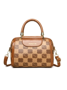 Close-up of Boston style handbag with bear pattern, leather handles and gold hardware