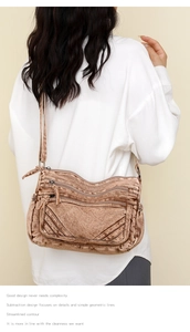Detail of vintage washed brown shoulder bag showing multiple zipper compartments and texture