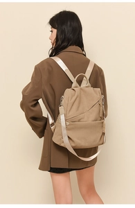 Side view of khaki corduroy backpack on model showing strap texture and zip detail