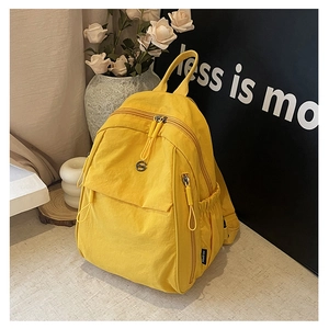 Détail du sac à dos jaune avec poches zippées multiples et tissu en nylon de haute qualité