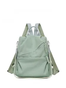 Front detail of bean green corduroy backpack with gray straps and woven zipper pulls