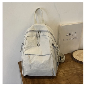 Détail du sac à dos en nylon crème avec tissu imperméable et poches multifonctionnelles