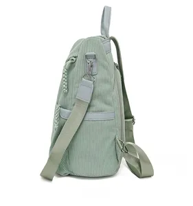 Side view of pale green corduroy backpack showing storage capacity and texture