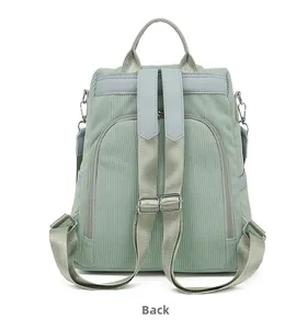 Back view of mint green corduroy backpack showing zipper pocket and adjustable straps