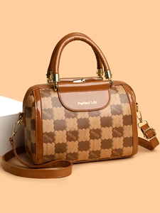 Detail of Boston bag with teddy bear checkerboard print and golden hardware