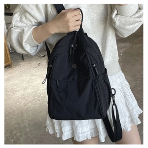 Sac à dos noir en nylon porté par un mannequin pour un look décontracté quotidien