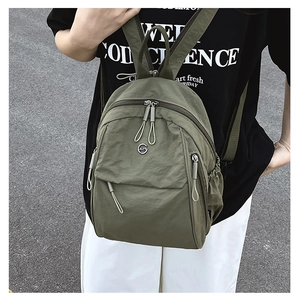 Sac à dos en nylon vert armée avec fermetures éclair porté pour un usage quotidien