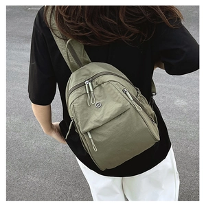 Sac à dos en nylon vert olive porté par un mannequin avec détails de zip en corde