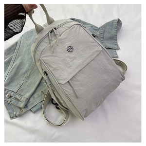 Détails du sac à dos en nylon gris clair avec logo métallique et fermeture éclair