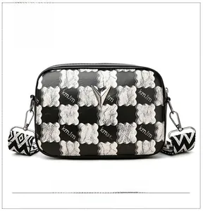 Détail du sac bandoulière à damier avec boucle en V argentée et sangle jacquard