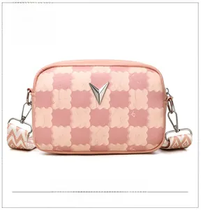 Détail du sac à bandoulière damier rose et beige avec logo V argenté et sangle brodée