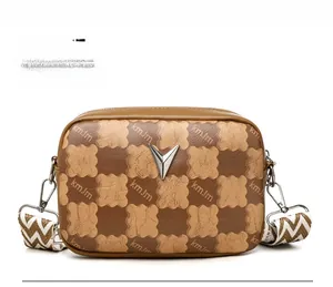Détail du sac bandoulière à damier avec logo en V métallique et sangle tissée large