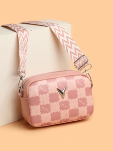 Détail du sac bandoulière rose à damier avec boucle en V argentée et sangle tissée