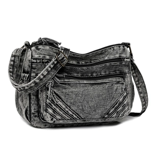Detailed texture of charcoal grey washed denim crossbody bag with multiple zip pockets