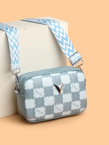 Détail du sac photo damier bleu avec logo V argenté et large bandoulière tissée