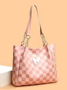 Détail d'un cabas rose avec motif de nuages matelassés et ornement papillon argenté