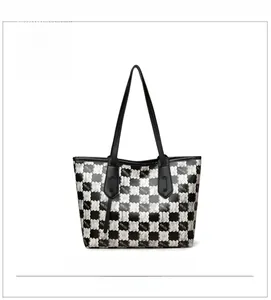 Detail view of large tote bag with black and white checkerboard bear print and slim handles