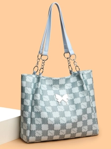 Vue détaillée du sac cabas bleu clair avec motifs en relief et pendentif papillon argenté
