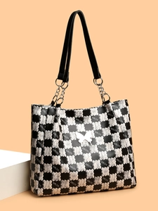 Détail du sac cabas à carreaux avec motifs d'ours et emblème de papillon en métal blanc