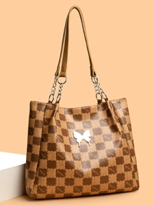 Détail du sac cabas à carreaux avec breloque papillon et bandoulière chaîne