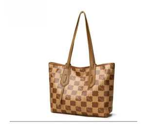 Detail shot of brown checkerboard tote bag featuring KMJM pattern and fine leather straps