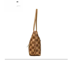 Side view of large brown monogram tote bag with leather straps on white background