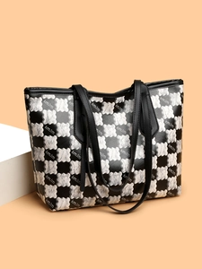 Detail of checkerboard tote bag with letter print and durable black handles