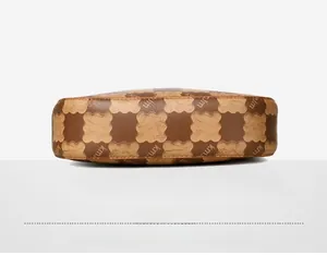 Detailed base view of brown handbag with kmjm monogram pattern and precise stitching